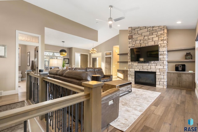 living area with lofted ceiling, a ceiling fan, wood finished floors, a fireplace, and baseboards