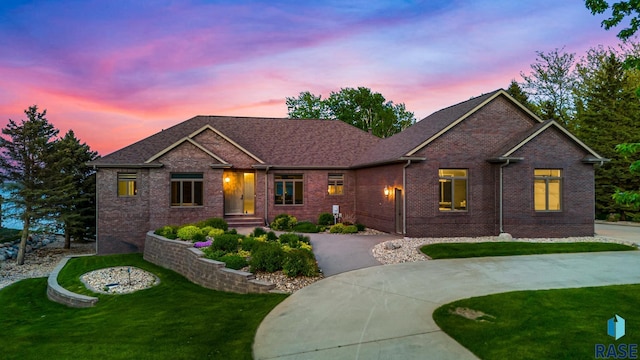 ranch-style home with brick siding, a front yard, and driveway