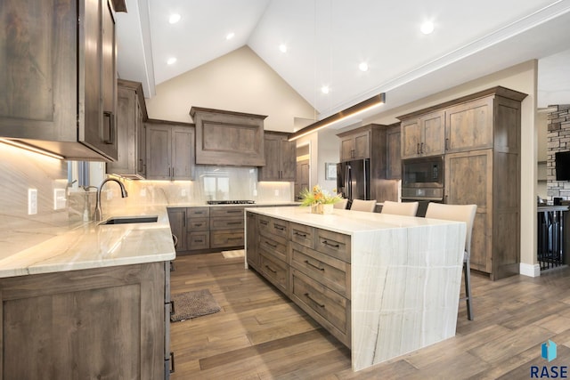 kitchen featuring a sink, built in microwave, refrigerator with ice dispenser, and wood finished floors