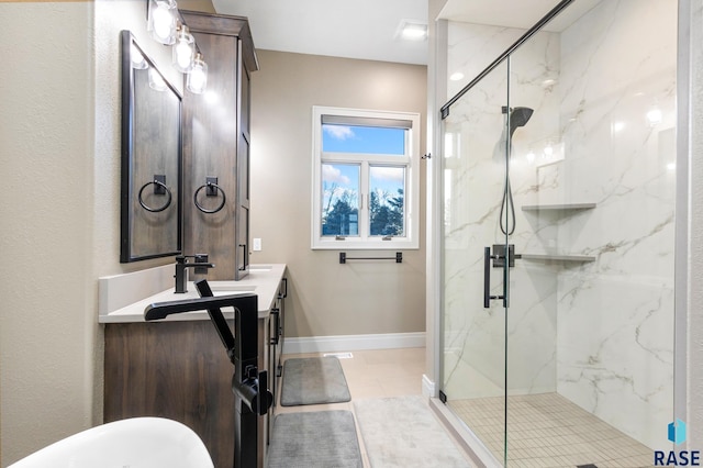 bathroom featuring a marble finish shower, vanity, and baseboards