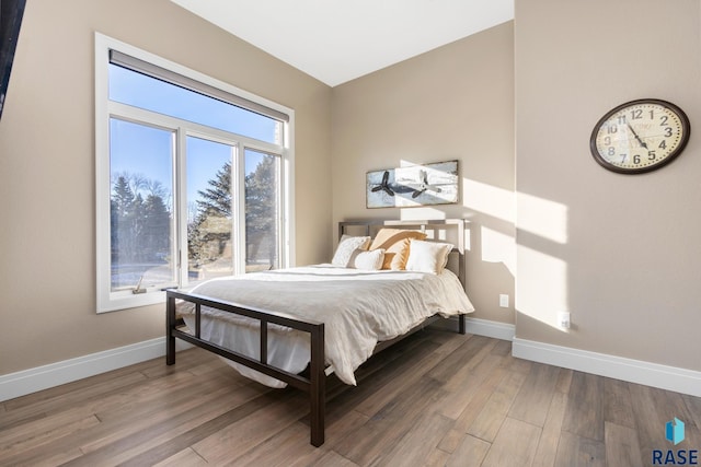 bedroom with baseboards and wood finished floors