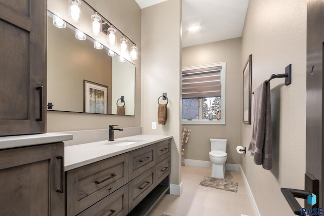 bathroom featuring vanity, tile patterned floors, toilet, and baseboards