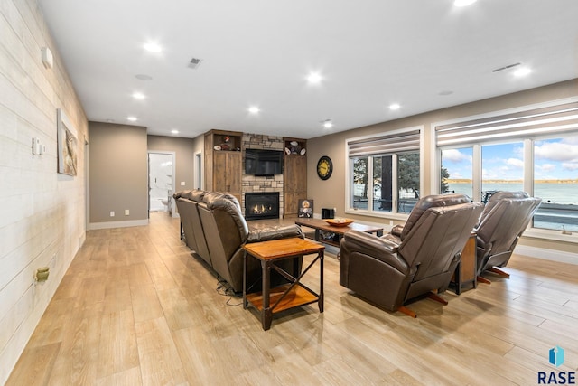 living area with visible vents, a fireplace, and light wood-type flooring