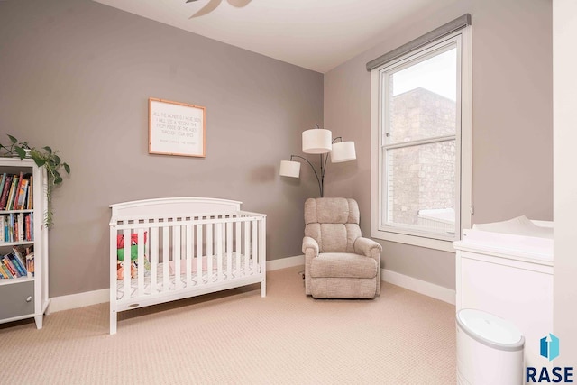 bedroom with baseboards, multiple windows, carpet, and a crib