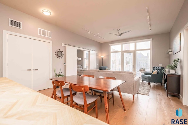 dining room featuring visible vents, light wood-style flooring, and rail lighting