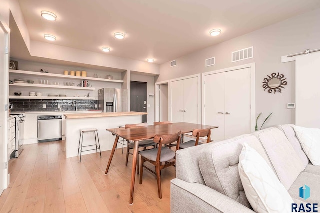 dining room with visible vents and light wood-type flooring