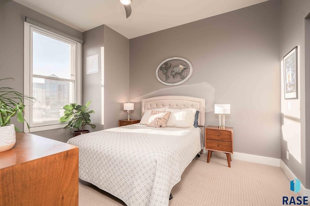 carpeted bedroom with ceiling fan and baseboards