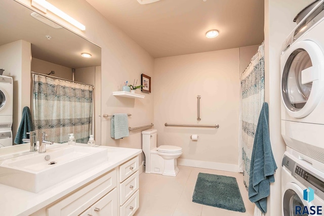 bathroom with tile patterned floors, baseboards, stacked washer and dryer, and toilet