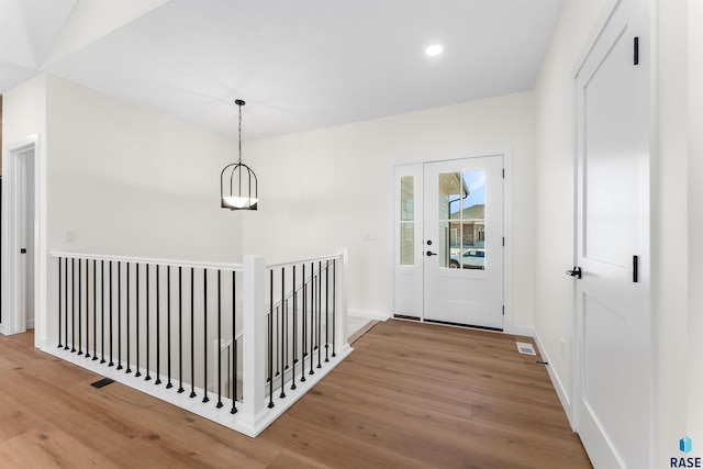 hallway featuring visible vents, an upstairs landing, wood finished floors, recessed lighting, and baseboards