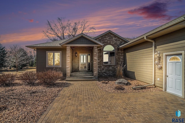 doorway to property featuring brick siding