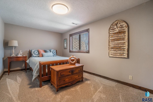 bedroom featuring light carpet, visible vents, a textured ceiling, and baseboards