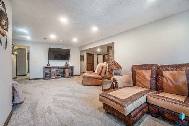 living area featuring baseboards, light carpet, and a textured ceiling