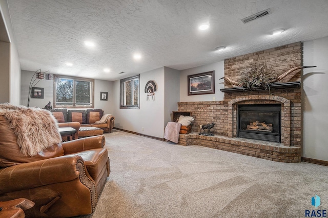 living area featuring visible vents, carpet floors, a textured ceiling, and a fireplace