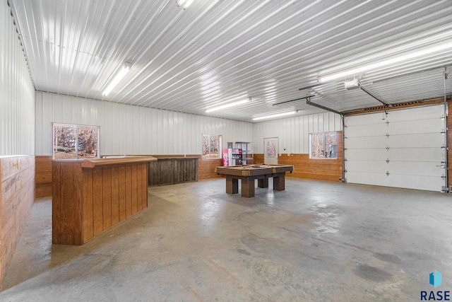 garage featuring a garage door opener and metal wall