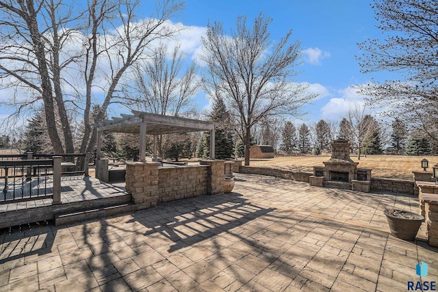 view of patio featuring a wooden deck, a pergola, and an outdoor stone fireplace