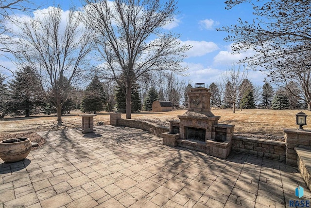 view of patio with an outdoor stone fireplace