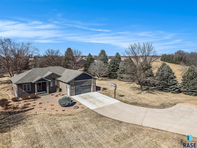 view of front of property with stone siding, roof with shingles, concrete driveway, and an attached garage