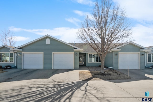 ranch-style house with concrete driveway and an attached garage