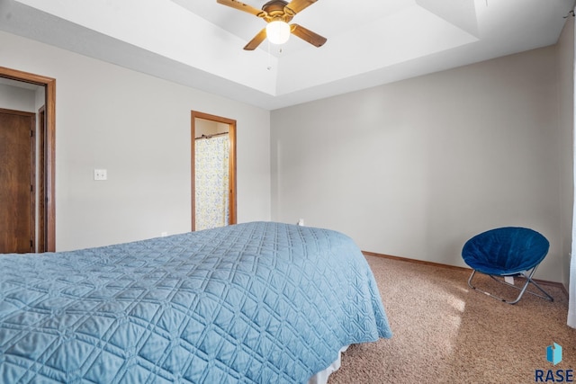 bedroom with a raised ceiling, a ceiling fan, baseboards, and carpet floors