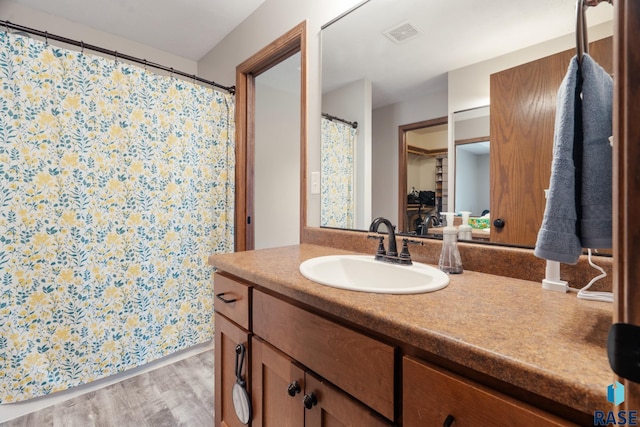 bathroom with vanity, wood finished floors, and visible vents