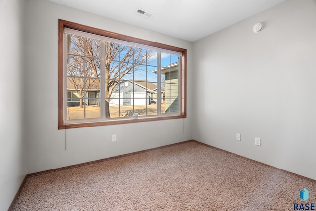 carpeted empty room featuring baseboards and visible vents