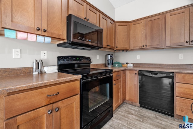 kitchen with light wood-type flooring, brown cabinets, and black appliances