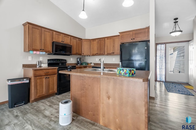 kitchen featuring a sink, brown cabinets, black appliances, and hanging light fixtures