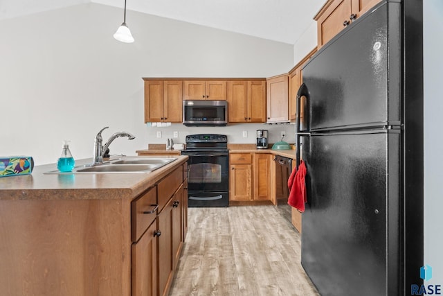 kitchen with light wood finished floors, vaulted ceiling, brown cabinets, black appliances, and a sink