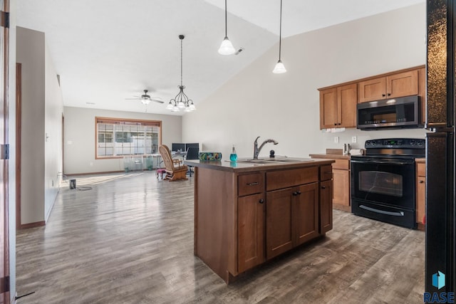 kitchen with dark wood-style floors, stainless steel microwave, black / electric stove, and a sink