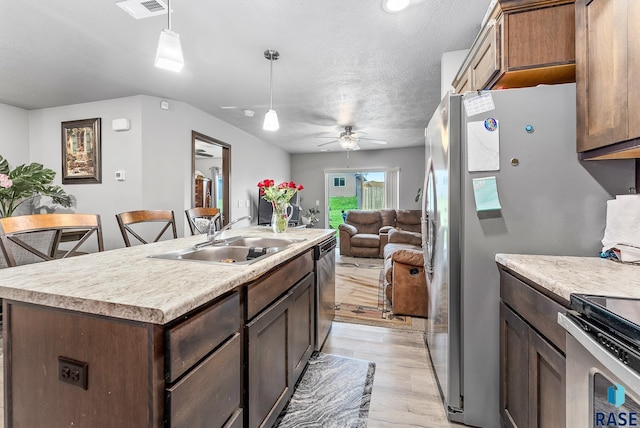 kitchen featuring visible vents, open floor plan, pendant lighting, appliances with stainless steel finishes, and a sink