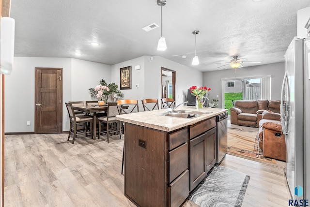 kitchen featuring a sink, light wood-type flooring, open floor plan, and stainless steel appliances