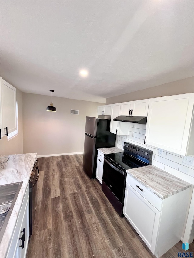 kitchen with visible vents, black appliances, under cabinet range hood, dark wood finished floors, and decorative backsplash