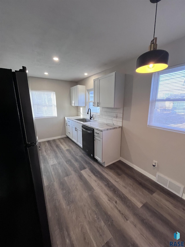 kitchen with visible vents, a sink, freestanding refrigerator, decorative backsplash, and dishwasher