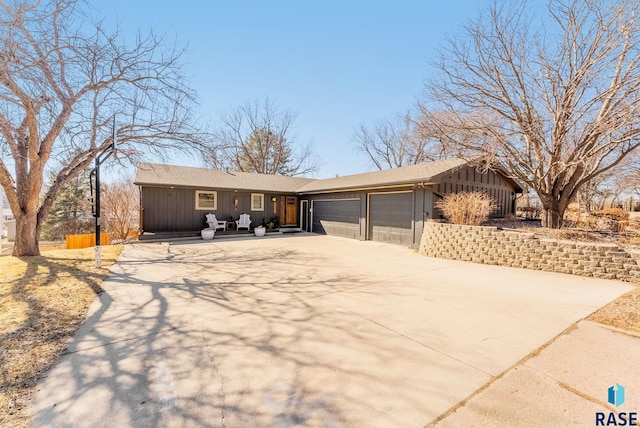 ranch-style home with board and batten siding, concrete driveway, and a garage