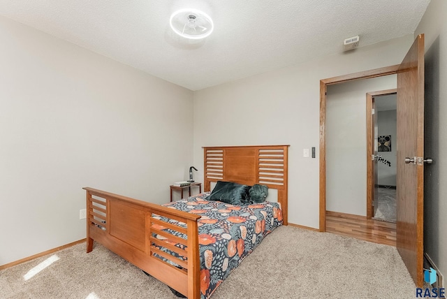 carpeted bedroom featuring baseboards and a textured ceiling