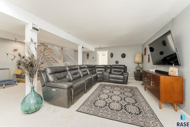 living room featuring light carpet, stairway, and a textured ceiling