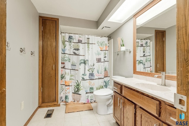 full bathroom with vanity, visible vents, a skylight, tile patterned flooring, and toilet