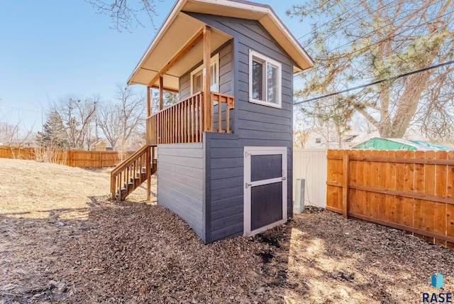 view of outbuilding with stairway and a fenced backyard