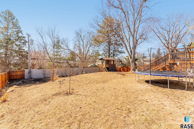 view of yard featuring a trampoline and a fenced backyard