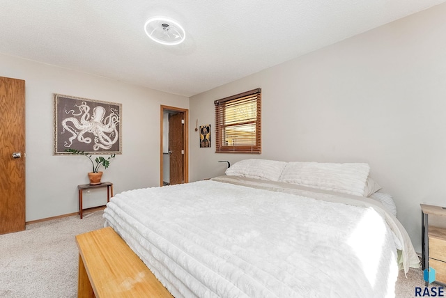 bedroom with carpet flooring, baseboards, and a textured ceiling