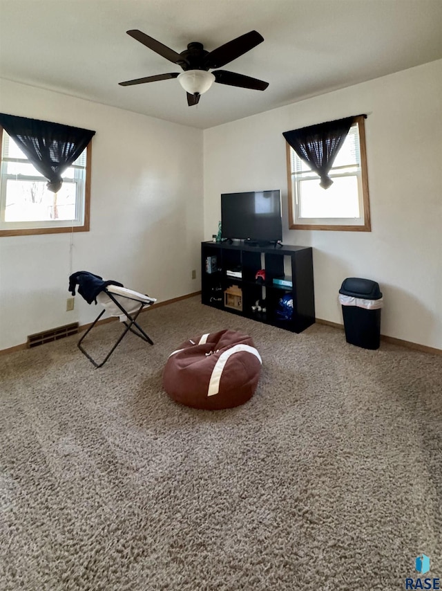 unfurnished living room with baseboards, a healthy amount of sunlight, visible vents, and ceiling fan