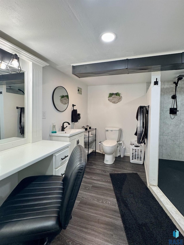 full bath featuring toilet, a stall shower, a textured ceiling, wood finished floors, and vanity