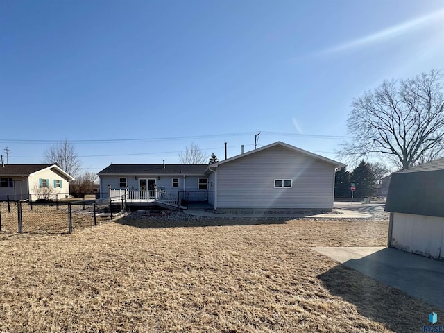 rear view of house with a wooden deck and fence