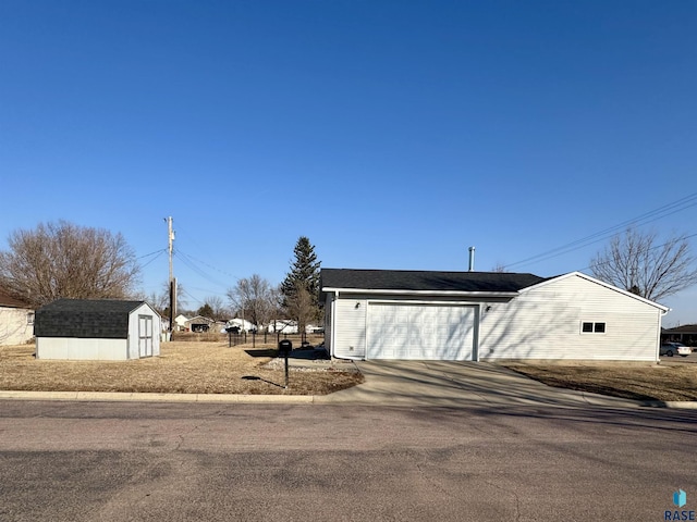 garage featuring a storage unit and driveway