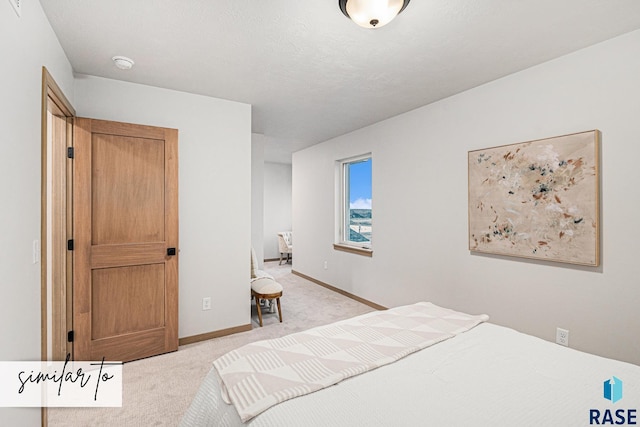 bedroom featuring light colored carpet and baseboards