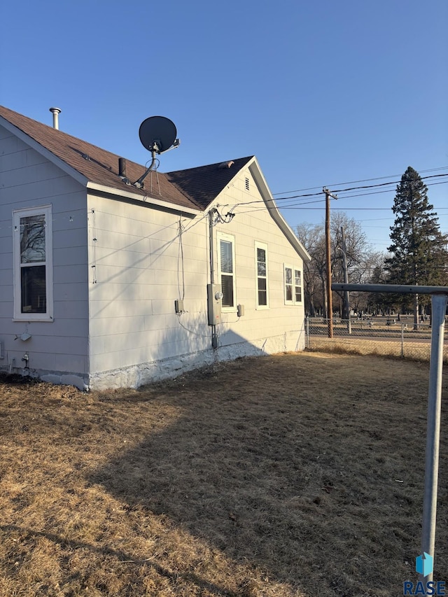 view of home's exterior featuring a lawn and fence