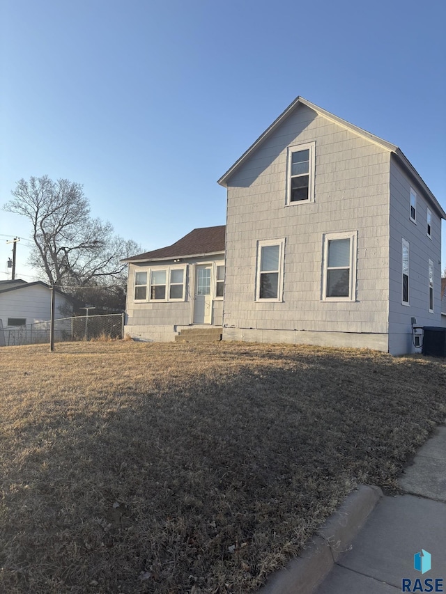 view of front facade featuring central AC and fence