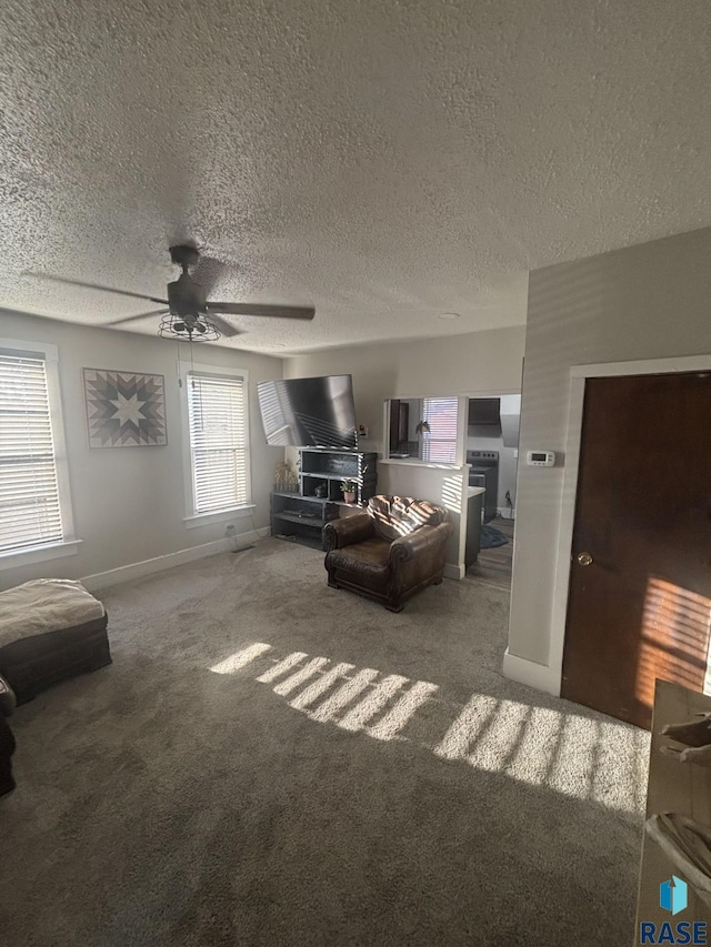 carpeted living area featuring a textured ceiling, baseboards, and ceiling fan