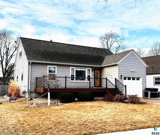 view of front of home featuring a front yard, an attached garage, and a shingled roof