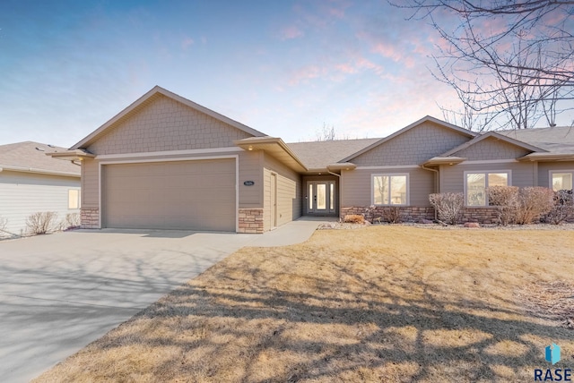 view of front facade featuring stone siding, an attached garage, and concrete driveway